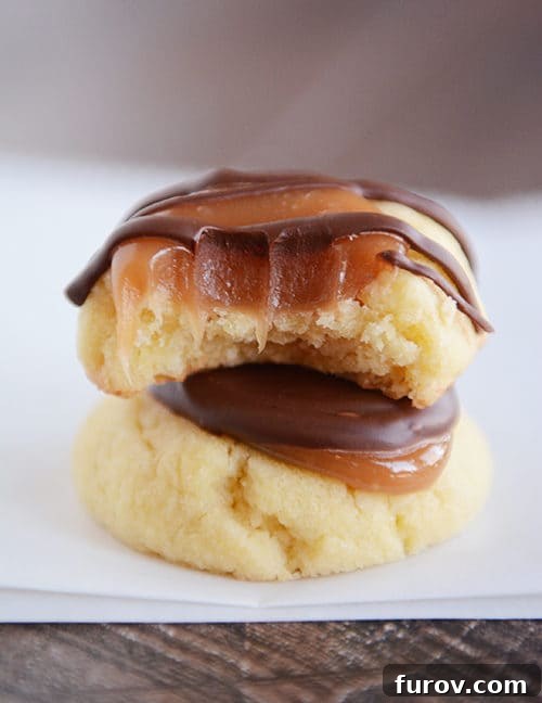 Caramel Chocolate Shortbread Delights 2 Two caramel, chocolate shortbread cookies stacked on each other, with the top one with a bite taken out.