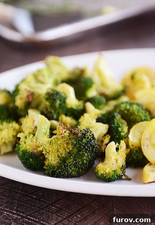 A close-up of a plate featuring crispy roasted broccoli and tender, golden squash, highlighting the enticing texture achieved through roasting.
