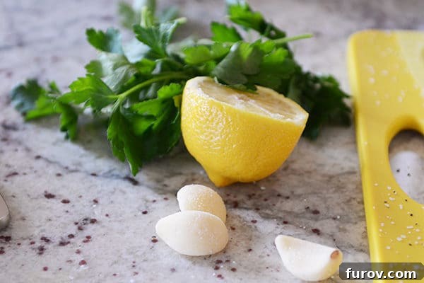 Three garlic cloves, half a lemon, and sprigs of parsley. 