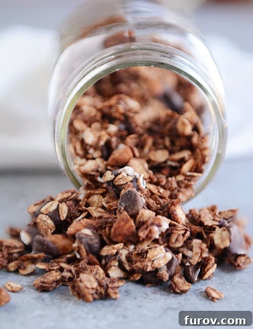 Chocolate granola spilling out of a mason jar.