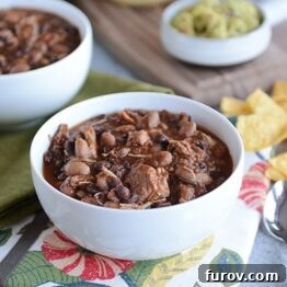 A small thumbnail image of the finished pressure cooker chicken and black bean chili, garnished with a swirl of sour cream and fresh cilantro.