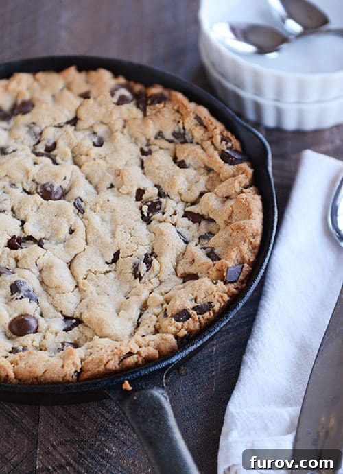 A chocolate chip cookie baked in a large skillet.