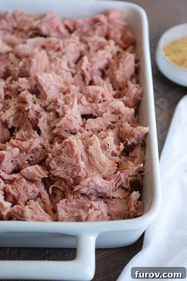 Sweet Glazed Ham in the Instant Pot 2 A white dish full of shredded baked ham.