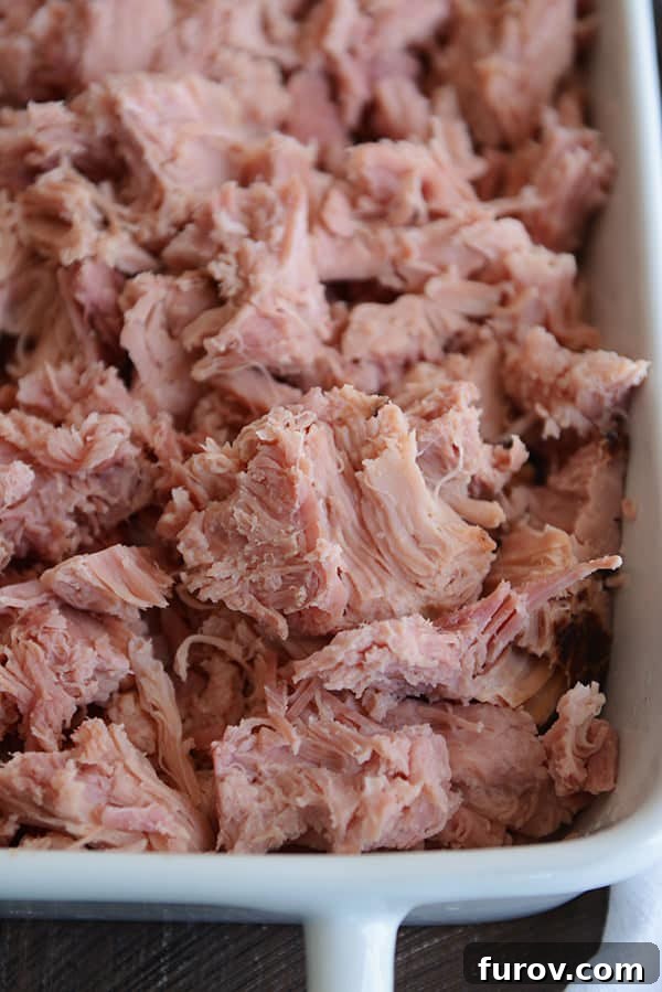 Sweet Glazed Ham in the Instant Pot 4 A white dish full of shredded, baked ham.