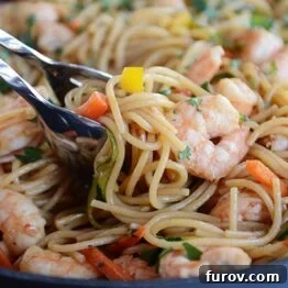 Close-up view of Asian garlic noodles with sauce, showcasing the texture and appeal of the dish before serving.