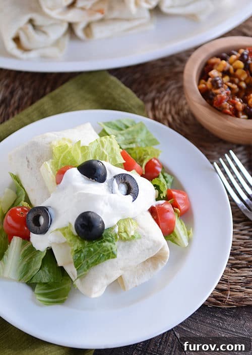 Wholesome Turkey and Brown Rice Taco Burritos 3 A burrito topped with lettuce, olives, sour cream and tomatoes.