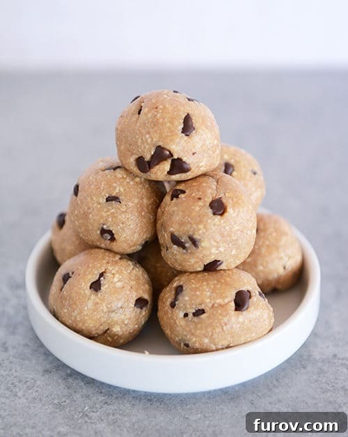 A stack of chocolate chip cookie dough bites on a small white plate, ready to be enjoyed.