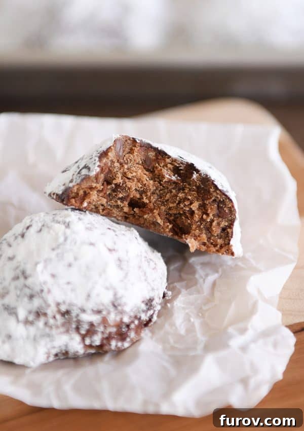 A perfectly broken chocolate truffle cookie revealing its dense, fudgy interior.