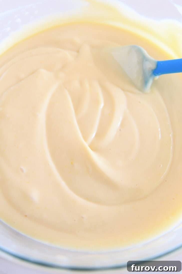 Top down view of a glass bowl with a creamy lemon pie filling.