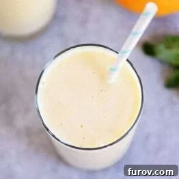 Close-up of a glass of refreshing Orange Dreamsicle Smoothie, garnished with a straw.