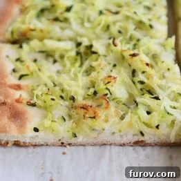 A delicious zucchini and cheese pizza slice, a perfect homemade dish.