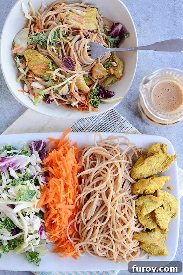 Thai Peanut Chicken Noodle Salad 5 Top view of a white platter with separate piles of chicken pieces, noodles, shredded carrots, and salad, alongside a bowl of all the mixed ingredients.