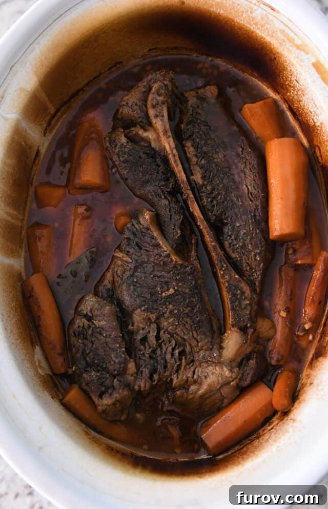 Melt-in-Your-Mouth Pot Roast and Savory Gravy 4 Cooked pot roast with tender carrots in the slow cooker, ready to be removed.