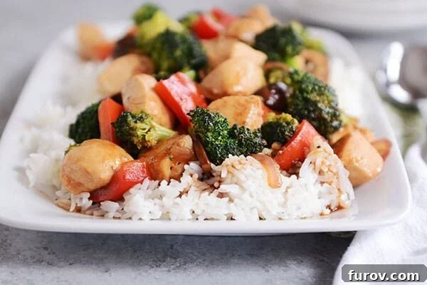 White rice covered with chicken and vegetable stir-fry. 