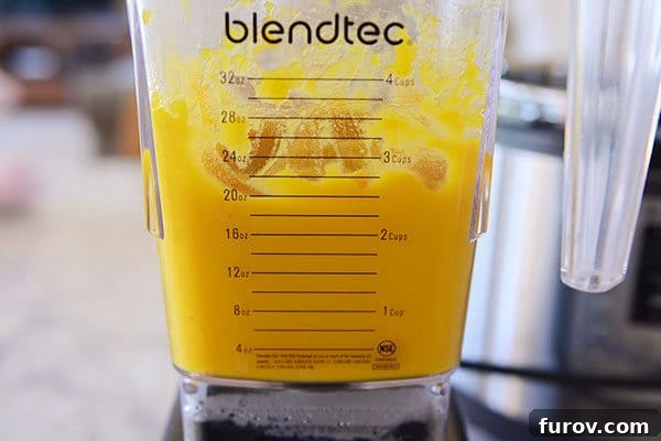 Quick and Easy Pressure Cooker Pumpkin Puree 11 A Blendtec blender containing perfectly smooth and creamy pumpkin puree, showcasing the vibrant orange color.