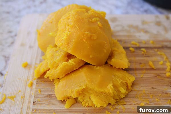 Quick and Easy Pressure Cooker Pumpkin Puree 10 Chunks of cooked pumpkin neatly arranged on a wooden cutting board, ready for blending.