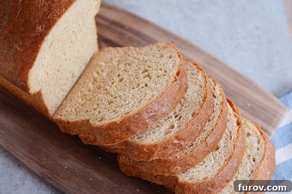 A loaf of sliced whole wheat bread on a cutting board.