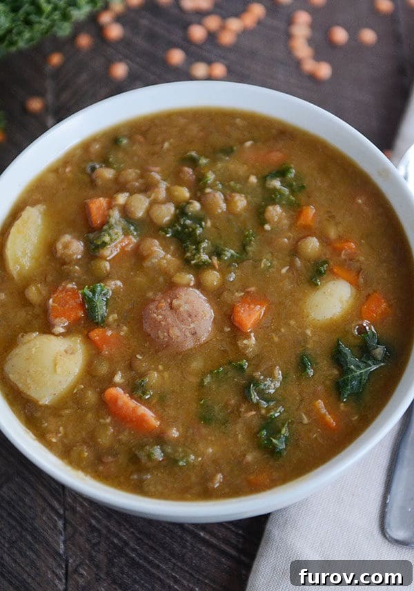Another perspective of the appetizing smoky lentil and potato soup, highlighting its comforting nature and rich ingredients like lentils, potatoes, and greens.