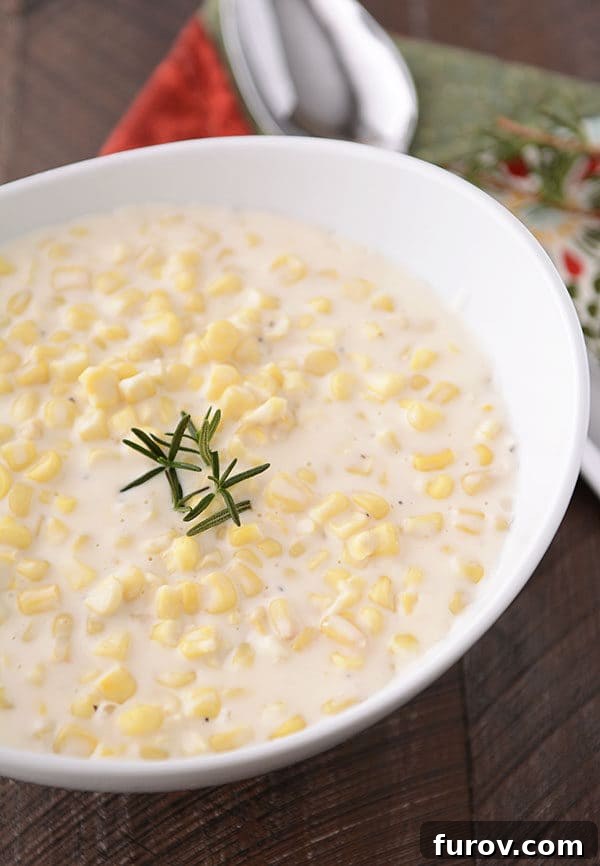 Velvet Parmesan Corn 3 A large oval white bowl brimming with warm, delicious parmesan cream corn, ready to be served.