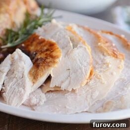 Simple Herb Roasted Turkey with Foolproof Gravy 7 Golden-brown slices of herb roasted turkey on a white platter.