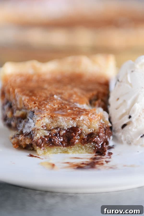 A beautifully gooey slice of chocolate chip pie on a white plate, with a bite playfully taken out, showcasing the melted chocolate and soft, rich texture that makes it irresistible.