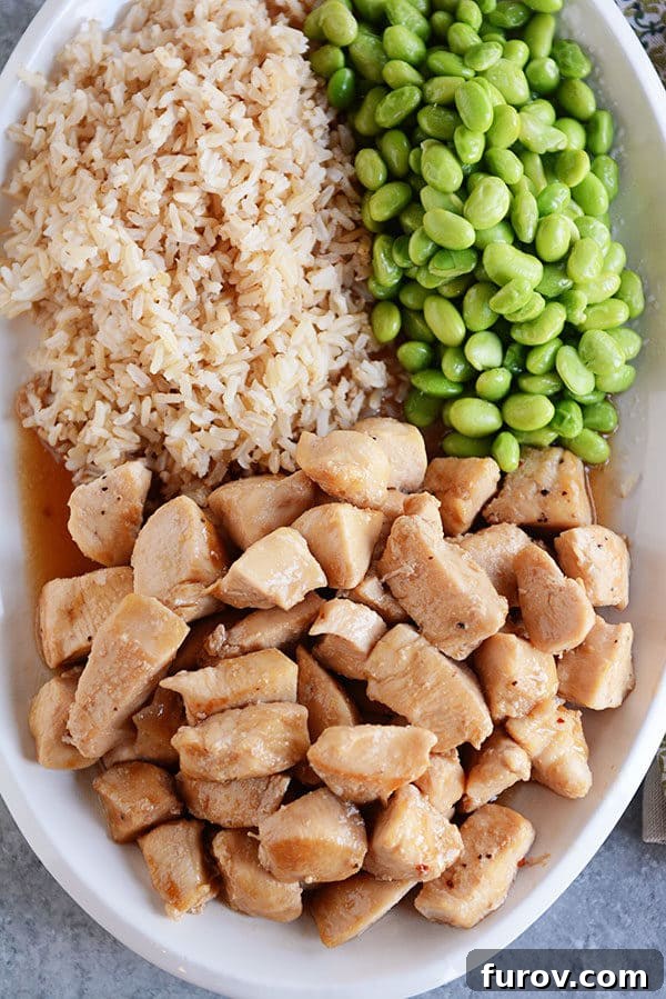 Sticky Honey Garlic Skillet Chicken in 20 Minutes 5 A large white oval platter with cooked chicken, lima beans, and cooked brown rice.