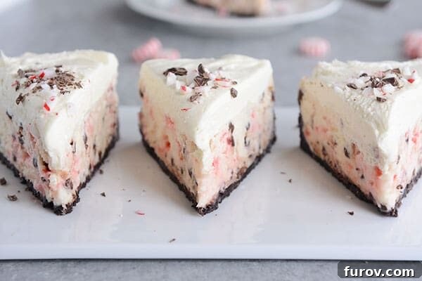 Three slices of peppermint white chocolate cheesecake lined up on a white platter, ready to be served.