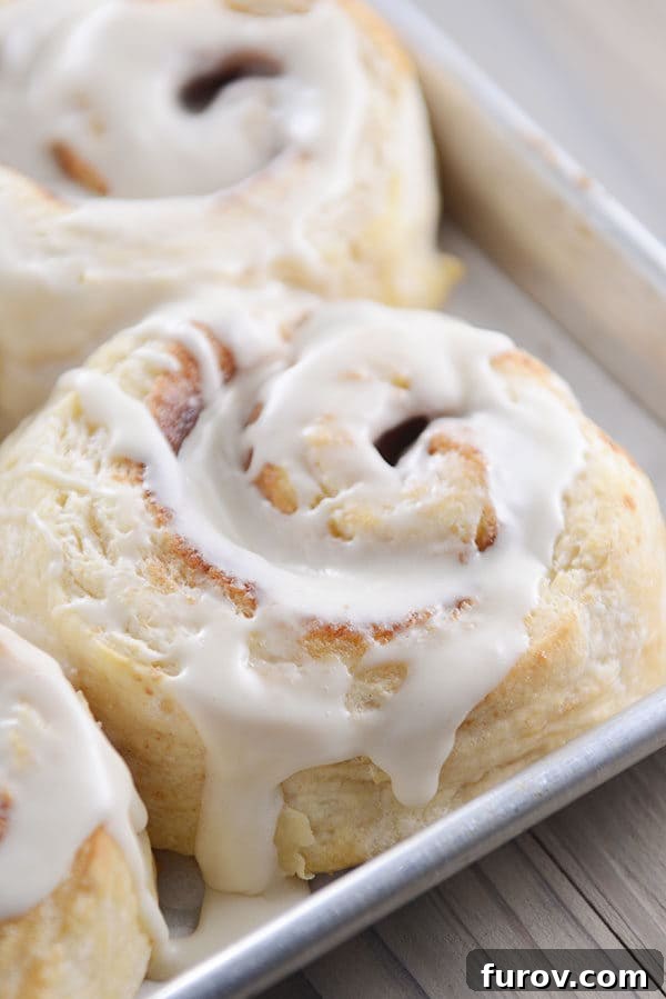 A cookie sheet full of perfectly frosted buttermilk biscuit cinnamon rolls, ready to be enjoyed.