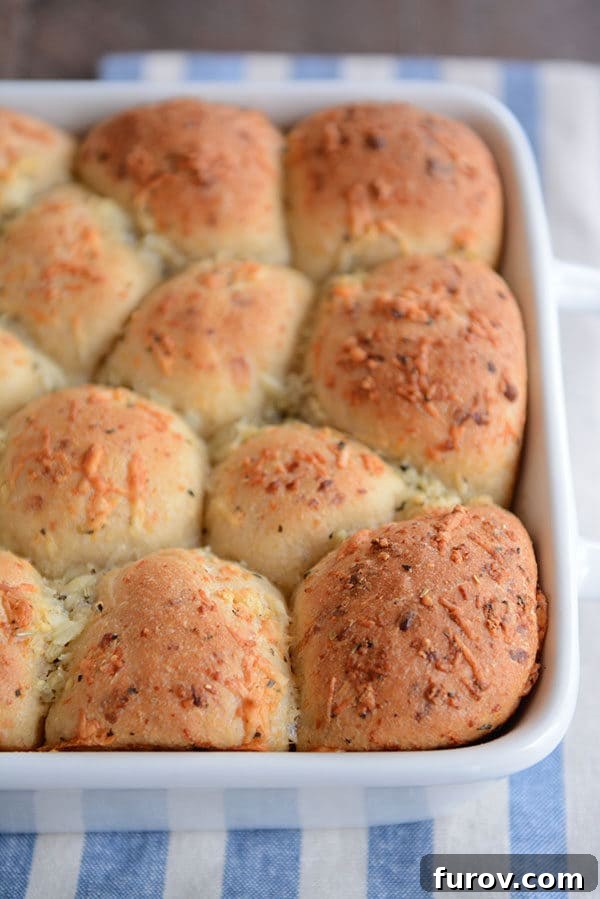 Golden Asiago Pull-Apart Loaf 2 A white pan of golden brown cooked asiago topped rolls.