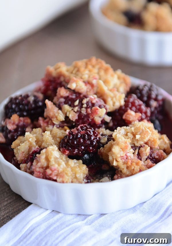 Simply The Best Berry Crisp Versatile and Delicious 4 A white dish heaped full of baked blackberry fruit crisp, showing the generous, golden-brown topping.