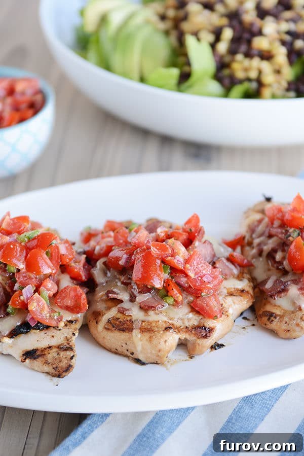 Three perfectly grilled Monterey Chicken breasts topped with vibrant pico de gallo, served alongside a refreshing salad with black beans and corn.