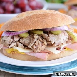 A delicious Cuban sandwich, with its layers visible, served on a white plate.