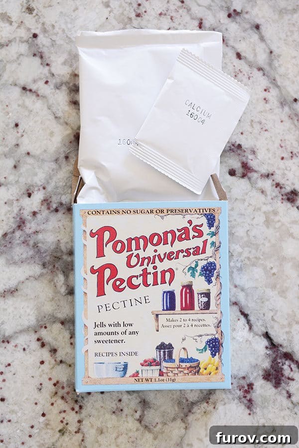 A box of Pomona's Universal Pectin with its contents, the pectin and calcium packets, neatly arranged on a kitchen countertop, ready for use.