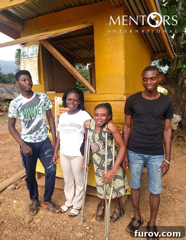Ghana: One Year On - Our Journey's Impact, Your Unseen Hand 5 Naomi proudly standing in front of her thriving village store, a symbol of her success with microloans.