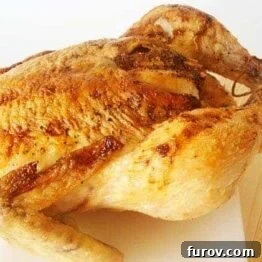 Close-up of a succulent honey-glazed roast chicken, showcasing its crispy skin and golden hue.