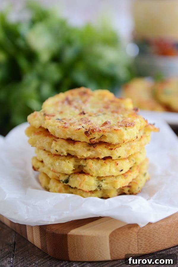 Crispy Baked Parmesan Spaghetti Squash Fritters 2 Five perfectly golden-brown baked spaghetti squash fritters arranged on a piece of parchment paper, ready to be served.