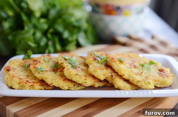 Crispy Baked Parmesan Spaghetti Squash Fritters 3 A beautiful lineup of golden-brown spaghetti squash fritters on an elegant white platter, showcasing their appealing texture.