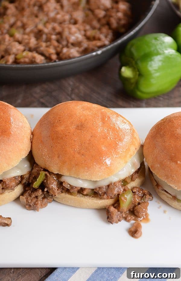 Top view of golden brown buns filled with a philly cheesesteak sloppy joe mixture.