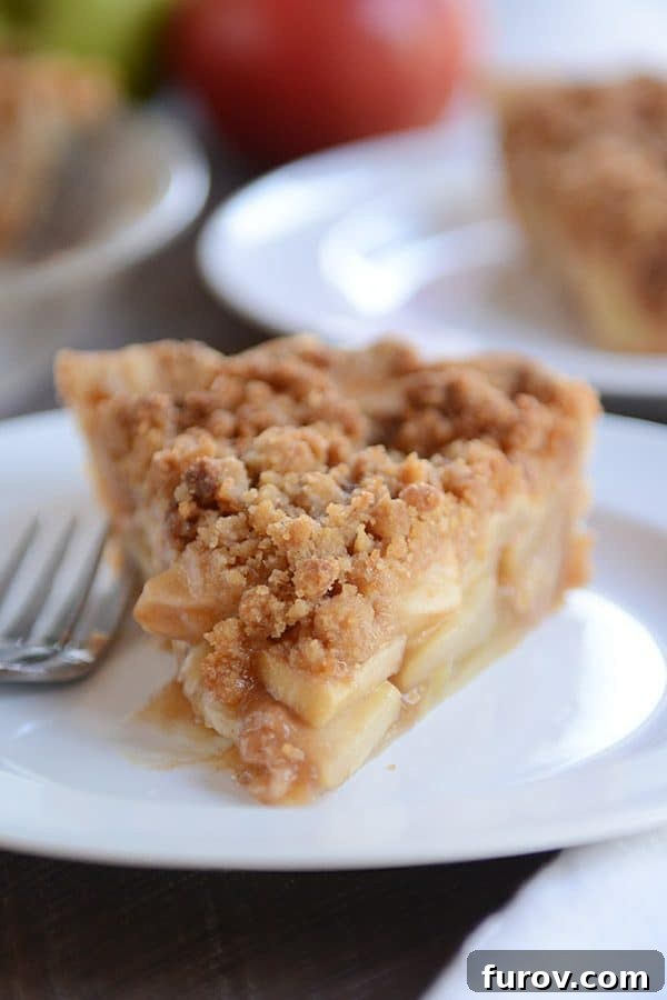 No-Fuss Apple Crumble Pie 7 A perfectly portioned piece of apple crumble pie presented on a simple white plate, ready to be enjoyed.