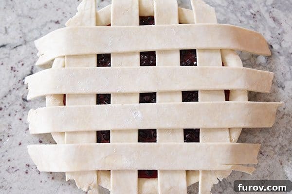 Top-down view of a berry pie with a simple, non-woven lattice crust, a quick alternative to traditional weaving.