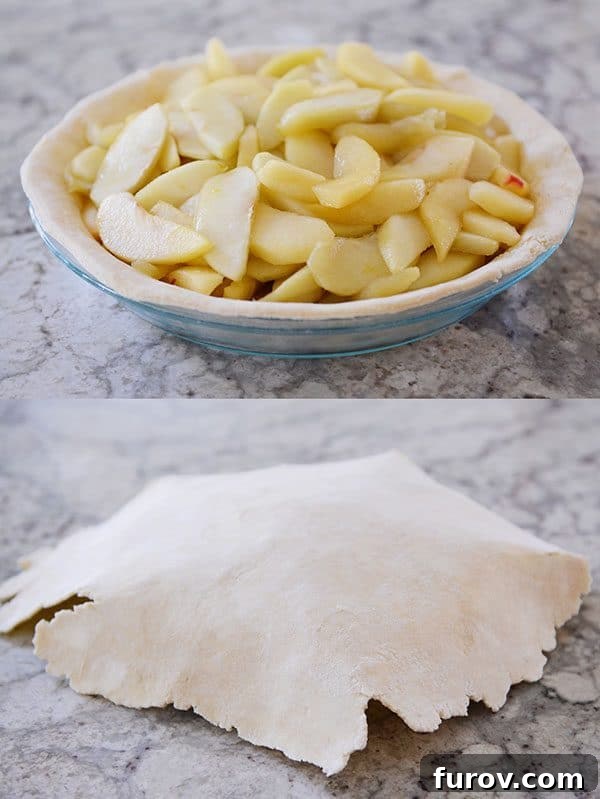 A pie dish filled with juicy apples, carefully being covered with a rolled-out, uncooked pie crust.