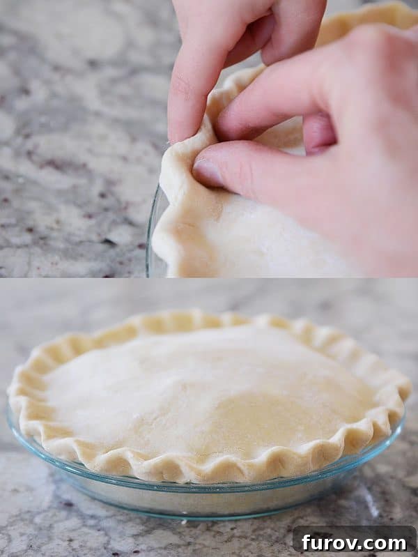 An uncooked apple pie with a beautifully crimped and fluted double crust, ready for baking.