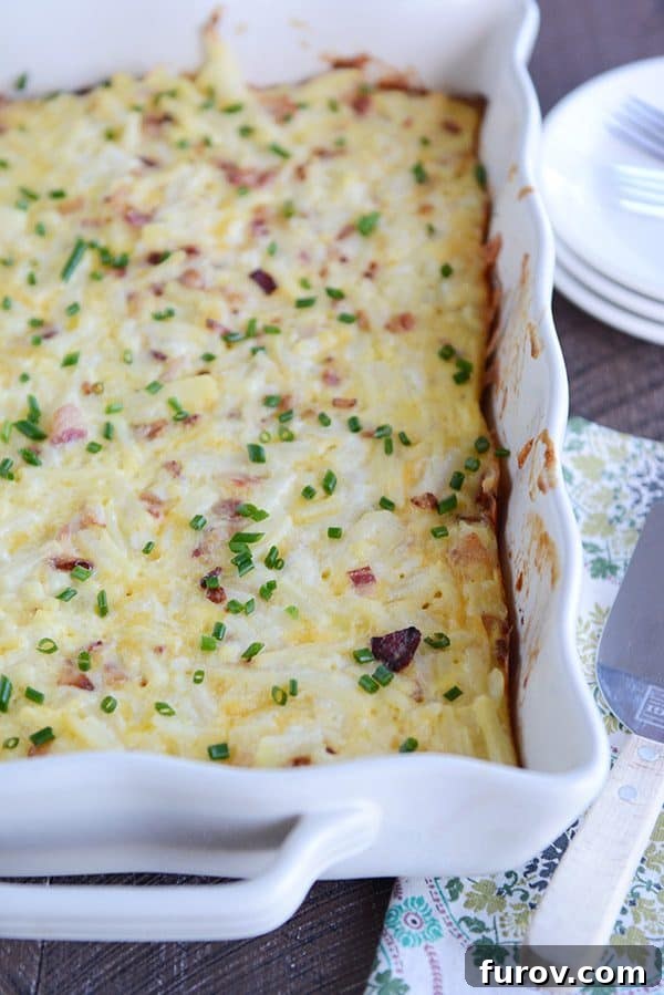 A white dish full of cheesy egg casserole sprinkled with green onion.