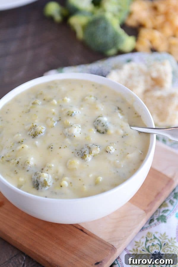 Spoon in white bowl filled with homemade broccoli cheese soup.
