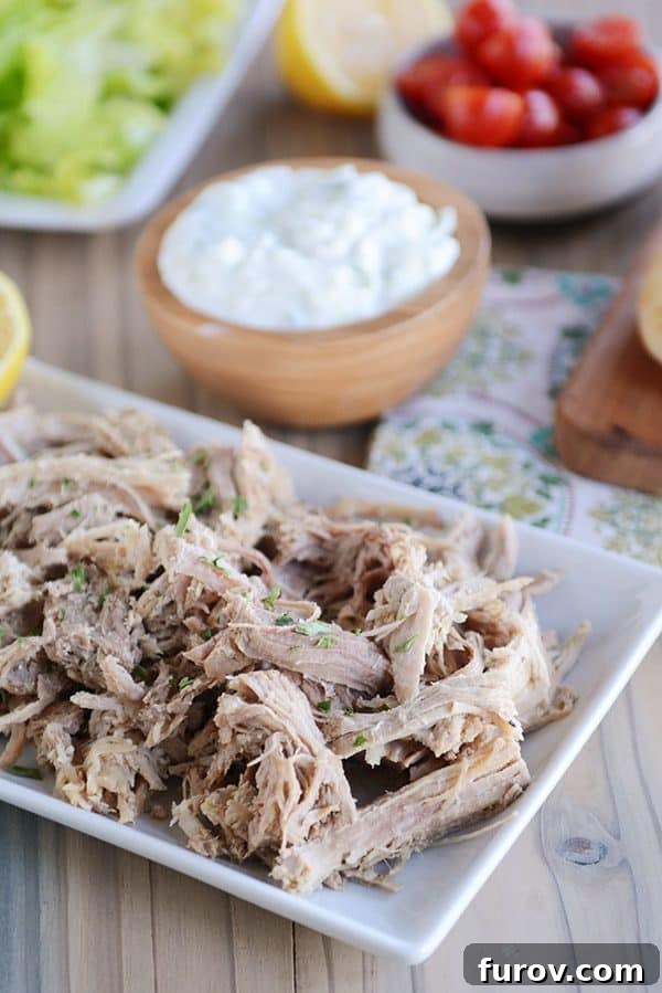Fall-Apart Tender Greek Pork Instant Pot or Slow Cooker 3 A white tray of shredded Greek pork.