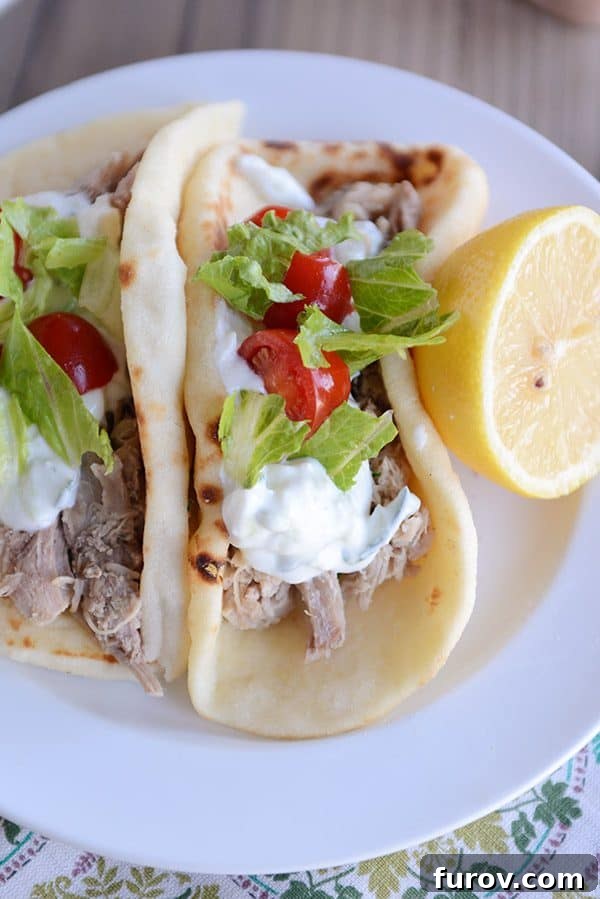 Fall-Apart Tender Greek Pork Instant Pot or Slow Cooker 4 Top view of a Greek pork taco on flatbread with a half lemon next to it.