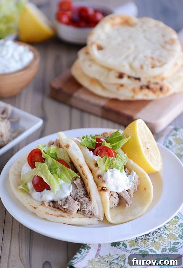 Fall-Apart Tender Greek Pork Instant Pot or Slow Cooker 5 Two pork tacos on flatbread on a white plate.