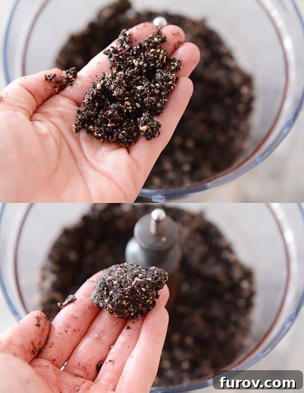 A hand holding dough of a dark chocolate almond joy bite ready to form it into a ball. 