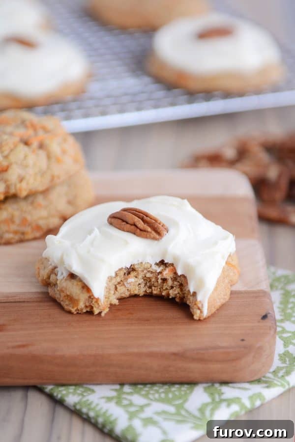 Heavenly Carrot Cake Cookies with Tangy Cream Cheese Frosting 2 Frosted carrot cake cookie with a bite taken out, showing its moist interior.