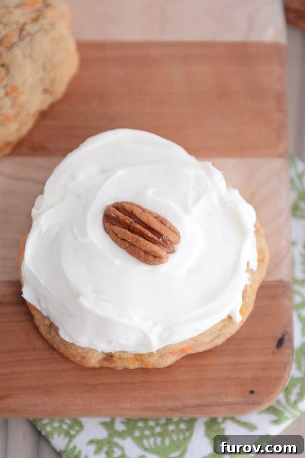 Heavenly Carrot Cake Cookies with Tangy Cream Cheese Frosting 4 Top-down shot of a frosted carrot cake cookie adorned with a toasted pecan.